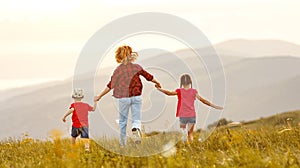 Happy woman with kids running back in field