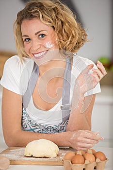 Happy woman kneading dough