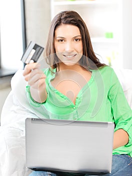 Happy woman with laptop computer and credit card