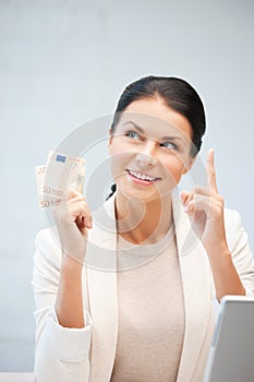 Happy woman with laptop computer and money