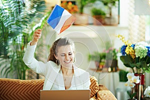 Happy woman with laptop and French flag learn foreign language