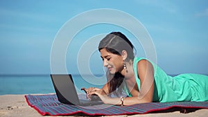 Happy woman with laptop on the summer beach