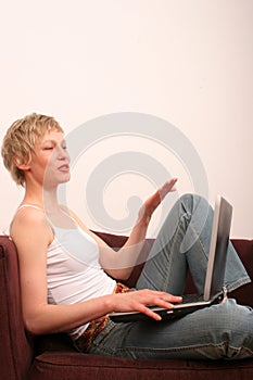 Happy woman with laptop is talking to somebody