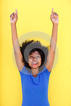 Happy woman laughing with arms raised pointing up