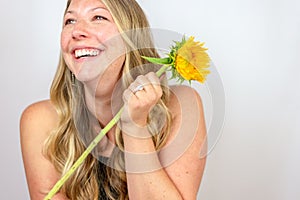 Happy woman laughing holding sunflower
