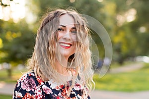 Happy woman laughing hotly on a city street. Close-up attractive caucasian woman with curly hair.