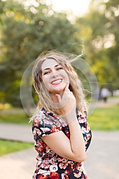 Happy woman laughing hotly on a city street. Close-up attractive caucasian woman with curly hair.