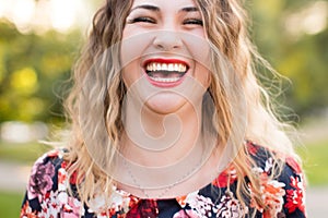 Happy woman laughing hotly on a city street. Close-up attractive caucasian woman with curly hair.