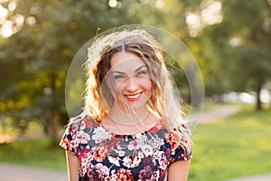 Happy woman laughing hotly on a city street. Close-up attractive caucasian woman with curly hair.