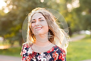 Happy woman laughing hotly on a city street. Close-up attractive caucasian woman with curly hair.