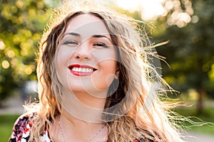 Happy woman laughing hotly on a city street. Close-up attractive caucasian woman with curly hair.