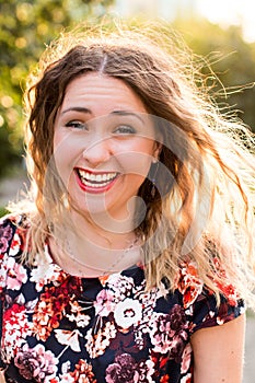 Happy woman laughing hotly on a city street. Close-up attractive caucasian woman with curly hair.