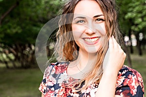 Happy woman laughing hotly on a city street. Close-up attractive caucasian woman with curly hair.