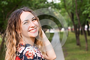 Happy woman laughing hotly on a city street. Close-up attractive caucasian woman with curly hair.