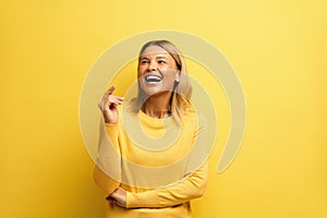 Happy Woman Laughing Isolated on Yellow. Young Girl Laughing Out Loud by Joke