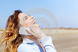 Happy woman laughing on the mobile phone