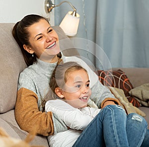 Happy woman laughing and tickle her daughter