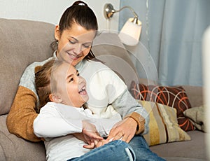 Happy woman laughing and tickle her daughter