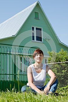 Happy woman on lawn in front of home