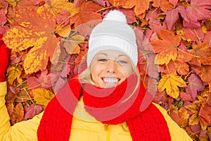 Happy woman laying in red leafs