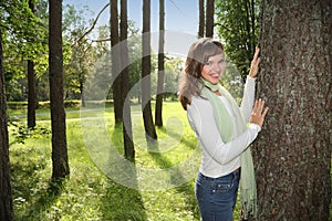 Happy woman leaning on tree