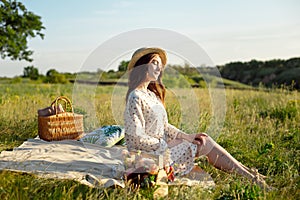 Happy Woman Life Style, beautiful relaxed girl in a straw hat on the nature picnic basket flowers in the rays of the