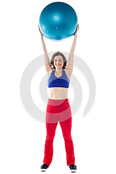 Happy woman lifting pilates ball upwards