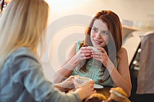 Happy woman listening to friend at coffee shop