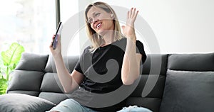 Happy woman listening to music on sofa in living room at home