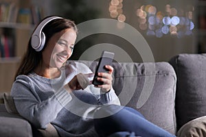 Happy woman listening to music using phone in the night