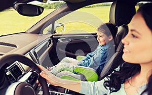 Happy woman with little girl driving in car