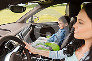 Happy woman with little girl driving in car