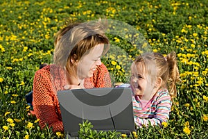 Happy woman and little girl relaxing outdoors