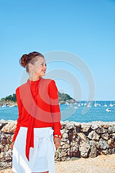 Happy woman looking aside in front of lagoon with yachts