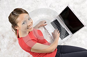 Happy woman looking backward with laptop