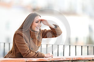 Happy woman looking forward from a balcony