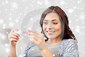 Happy woman looking at home pregnancy test