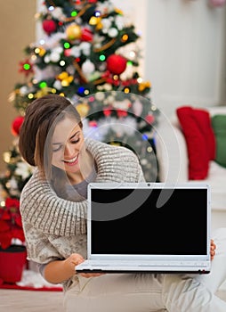 Happy woman looking laptop blank screen