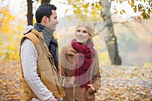 Happy woman looking at man during autumn