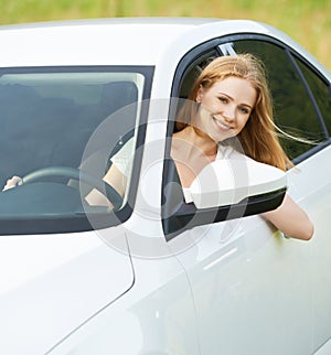 Happy woman looks out the car window on nature