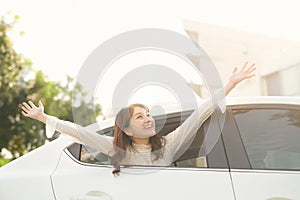 Happy woman looks out the car window on nature summer
