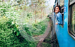 Happy woman looks out from train window during traveling on most