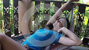 Happy woman lying in hammock relaxing on summer terrace action camera pov of young girl having rest