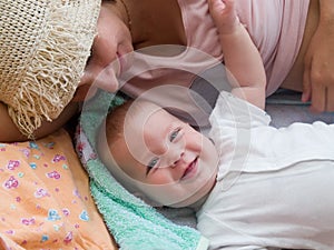 Happy woman lying on the sofa with laughing baby