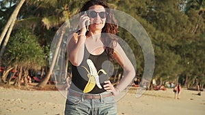 Happy woman makes phone call and talks on beach