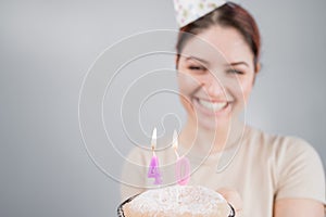 The happy woman makes a wish and blows out the candles on the 40th birthday cake. Girl celebrating birthday. Copy space.