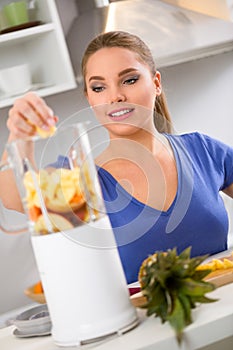 Happy woman making fruit juice