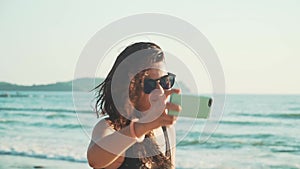 Happy woman making selfie on the beach