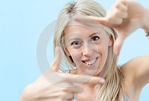 Happy woman making selfy photo frame around her face