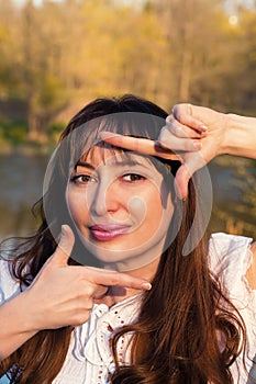 Happy woman making snapshot sign